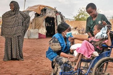 8 year old girl in wheelchair with head of WFP Wajir Field Office and her family.
