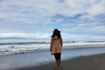 Dena M. Chasten standing on a beach. She found her birth parents and now works as a genealogist.