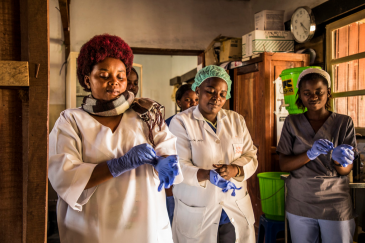 Health workers in the DRC put on gloves on before checking patients at the hospital.