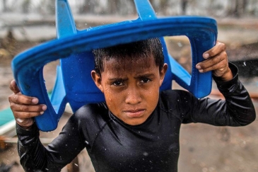 Young boy tries to shield himself from storm in Central America.