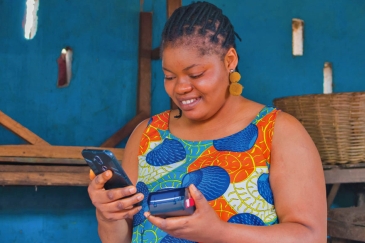 African woman entrepreneur with digital payment device.