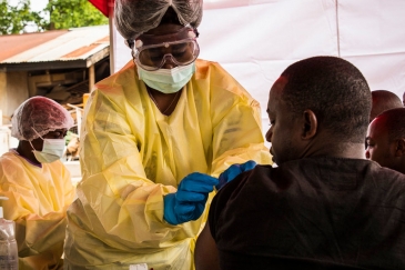 A health worker vaccinates a man against the Ebola virus in Beni