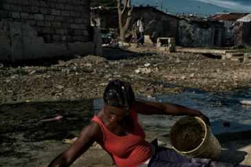 一名海地妇女正在为一家合作社制作“黏土蛋糕"，这种“蛋糕”用黏土、黄油加盐揉和，经日晒干燥制成，已成为海地极端贫穷与饥饿状况的象征。