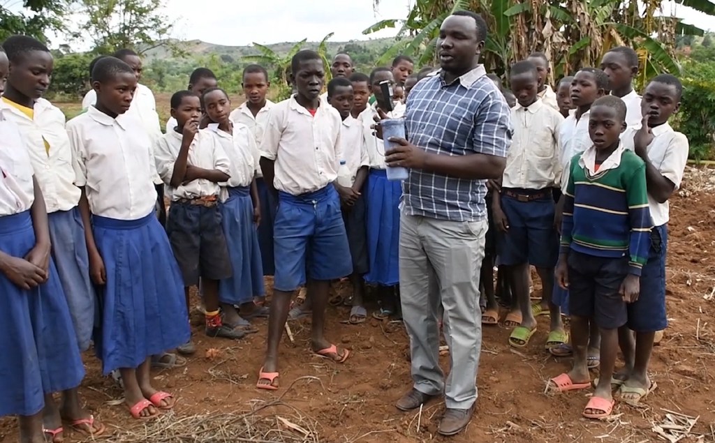 Wanafunzi kutoka shule ya msingi ya Minyinyi, nchini Tanzania na mwalimu wao ambaye anawafundisha kutumia kifaa cha kupima rutuba kwenye ardhi kwa ajili ya vipimo vya mbolea.