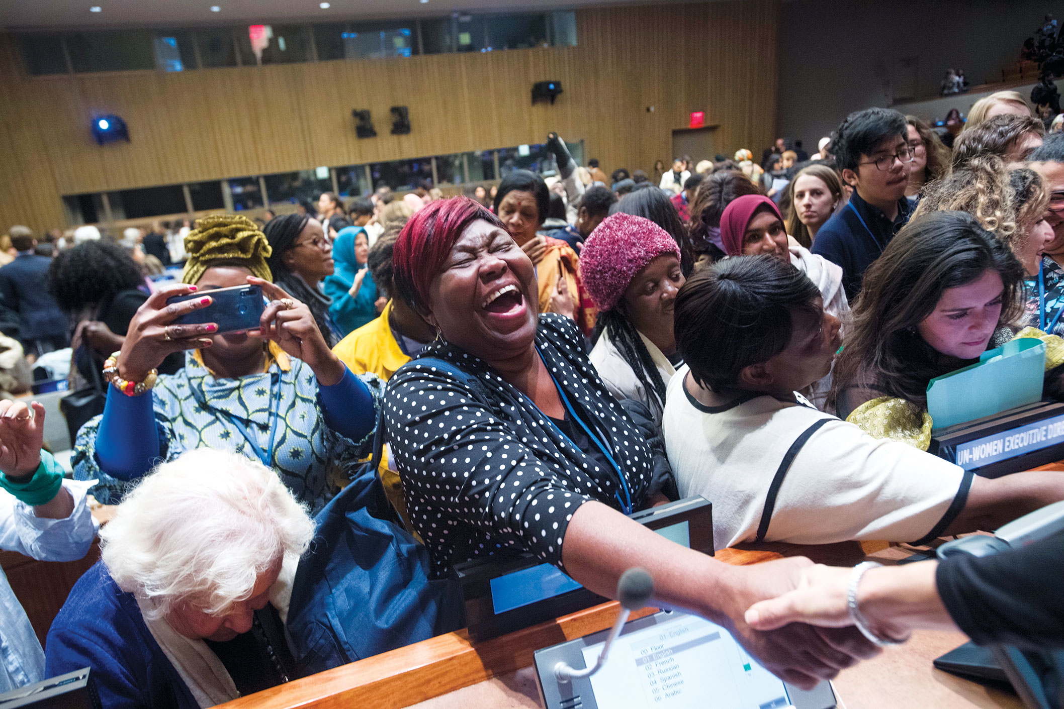 Photo of Commission on the Status of Women. (United Nations, New York; 12 March 2019) A participant of a townhall meeting greets a UN staff member