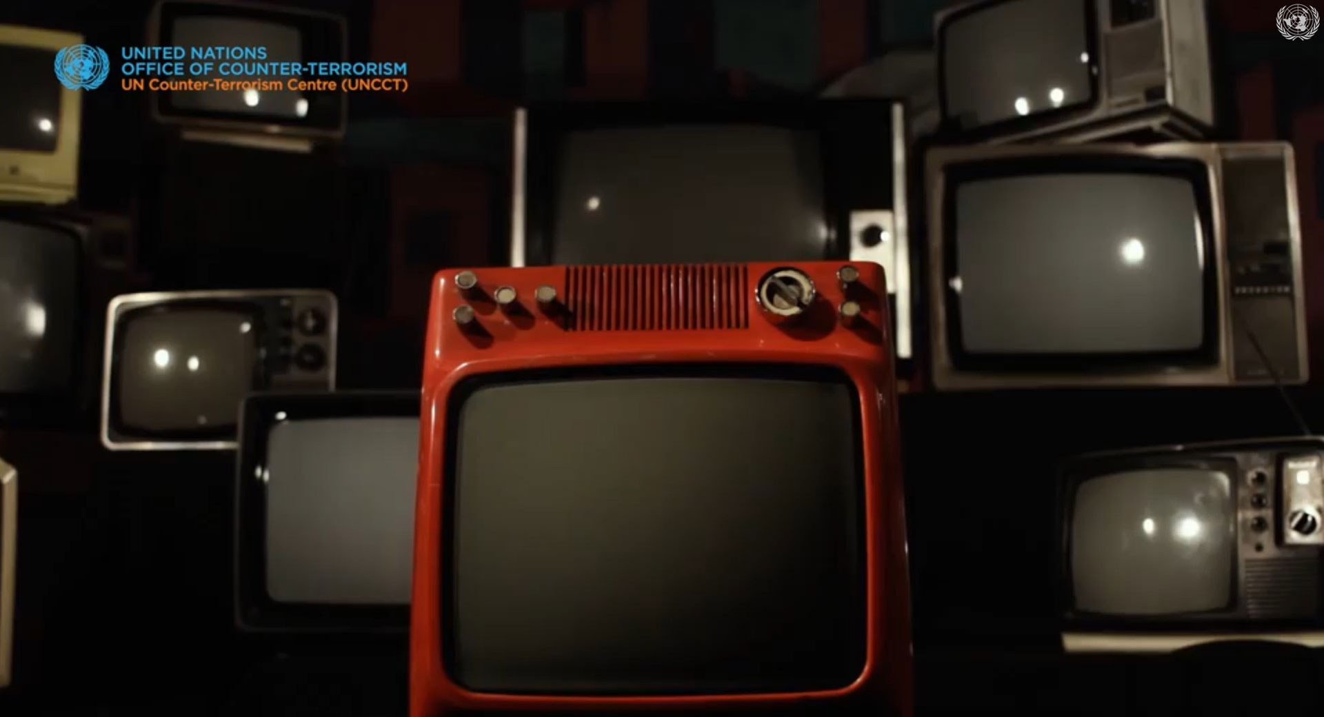 Pile of old televisions with one red standing at the front