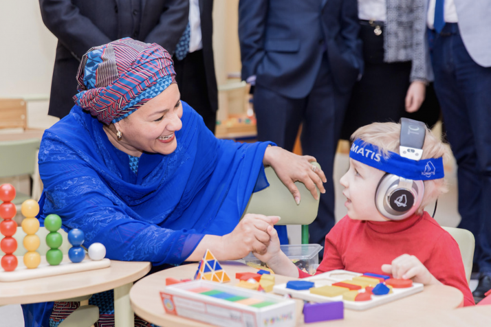 Deputy Secretary-General Amina Mohammed visits the Republican Rehabilitation Center for Disabled Children, on her first day in Minsk, Belarus. In this photo she talks to a small boy using a hearing device.