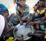 Children eating from a bowl of rice
