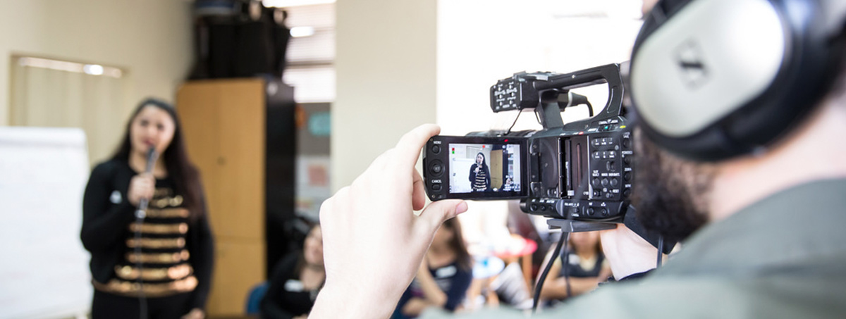 Participants learning how to film, speak in front of a camera and use a hand-mic.