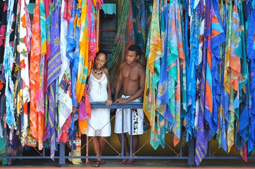 young couple in the sychelles market standing in the middle of hanging fabrics