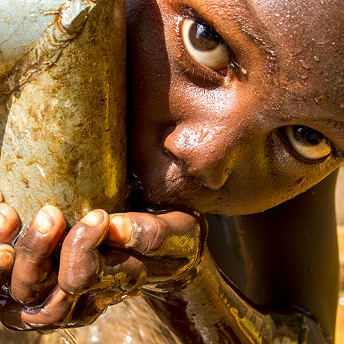 Marakera, an Ethiopian 5-year-old boy, drinks clean piped water.