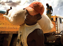 Homme transportant un sac de grains.  Photo: FAO