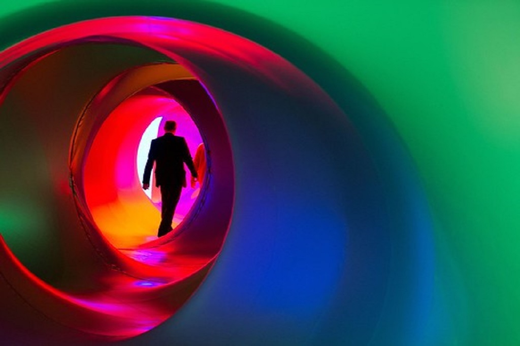 A visitor walks through an art sculpture called the “Luminarium