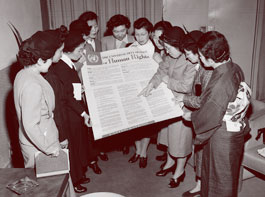 Un grupo de japonesas mirando a la Declaración Universal de los Derechos Humanos.