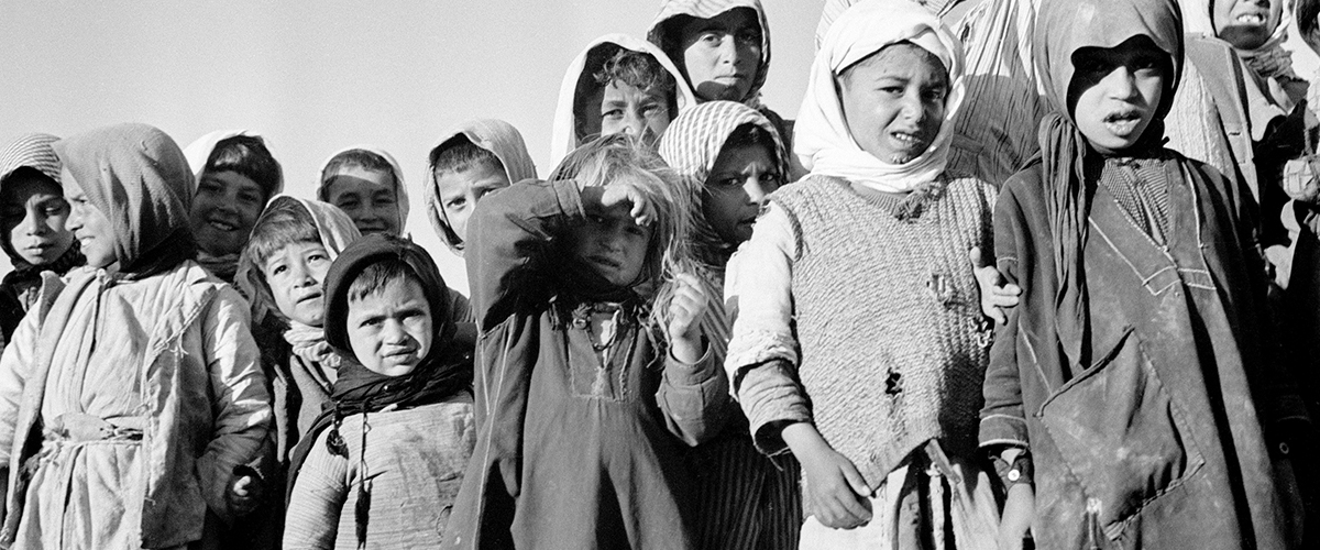 Unos niños esperan la distribución de leche de UNICEF el 1 de enero de 1950.