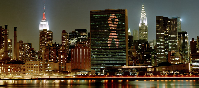 
El edificio de la Secretaría de las Naciones Unidas por la noche, iluminado con el lazo rojo de la lucha contra el SIDA