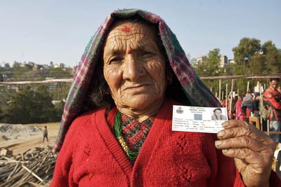 Ratna Thapa Maya, de 80 años de edad,  de la región central de Nepal muestra su tarjeta de registro de votantes después de caminar durante una hora y media para emitir su voto en la Asamblea Constituyente de elecciones de Nepal.