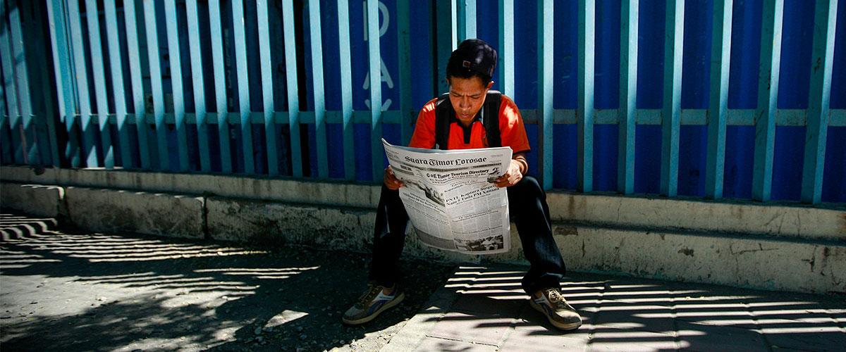 Joven leyendo el periódico en Dili (Timor-Leste).