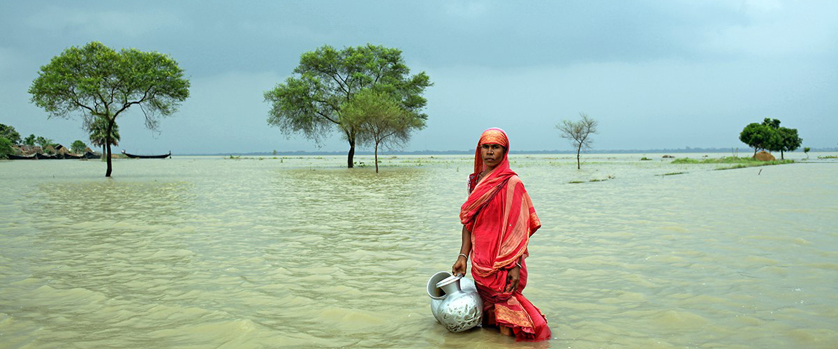 Mujer de Bangladesh en un lago sosteniendo unas cántaras de agua.