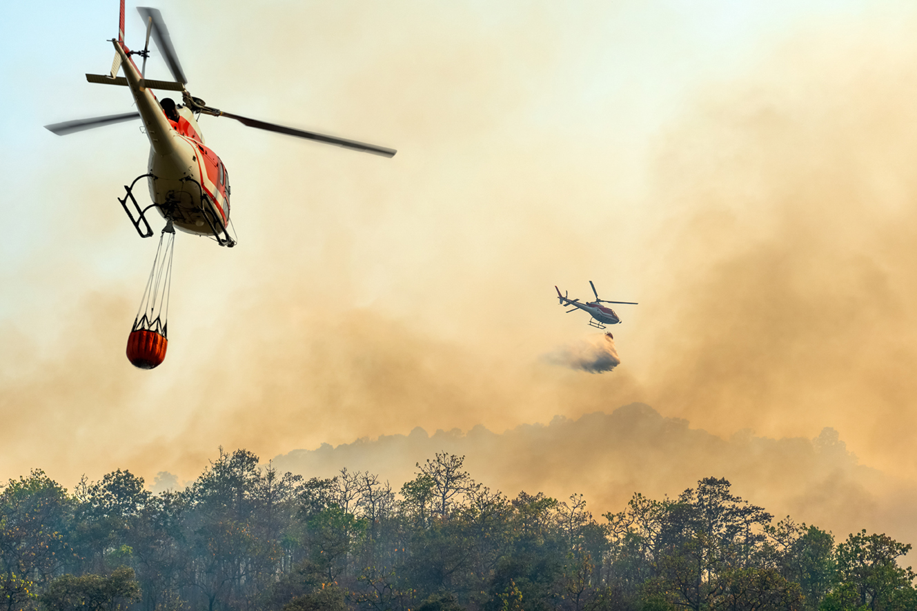Helicopter dumping water on forest fire