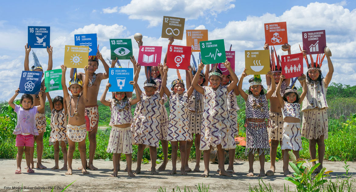 Des enfants autochtones tiennent des pancartes où figurent les objectifs de développement durable