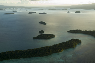 An aerial shot of a lagoon in the Solomon Islands at sunrise. There are several islands scattered throughout the lagoon.