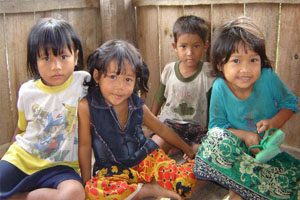 Four children sit in front of a camera.