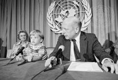 Person with children in front of the UN logo in black and white