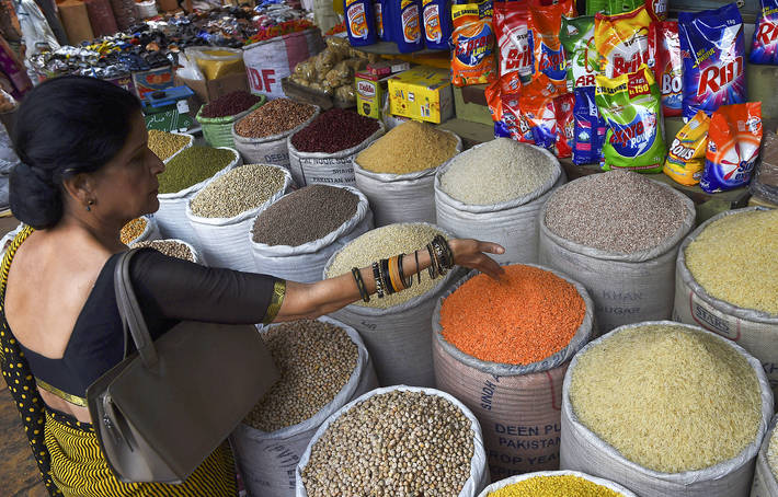 Chef Zubaida Tariq selecting pulses at a grocery stall at Empress Market, a famous market in downtown Karachi, Pakistan.