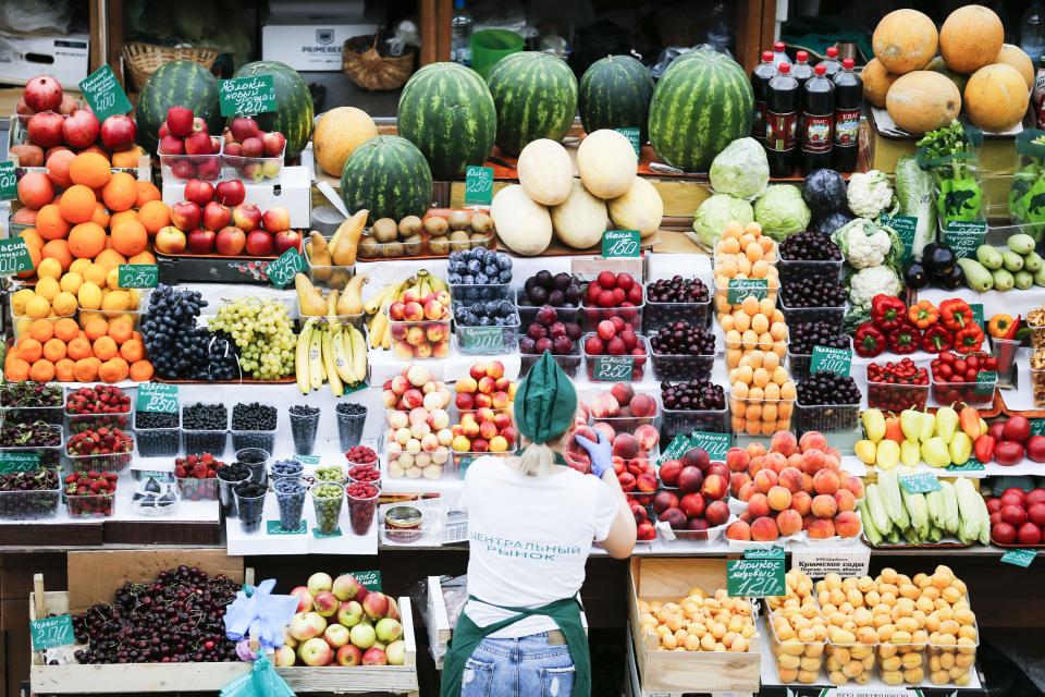 沃罗涅日中央市场，小贩在货摊摆放蔬菜水果。