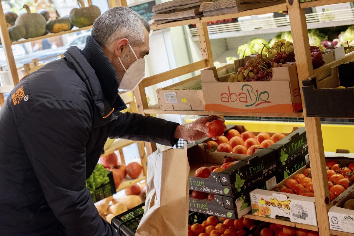 A customer buying fruit at an organic farm store during the COVID-19 pandemic.