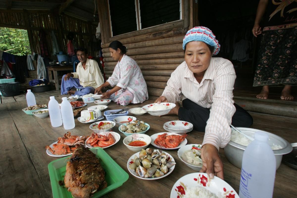 أسرة في جنوب آسيا مجتمعة حول المائدة لتناول الأغذية البحرية.