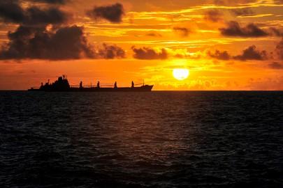 The sun rises over ships anchored off of Mogadishu, Somalia, waiting to offload their cargo.
