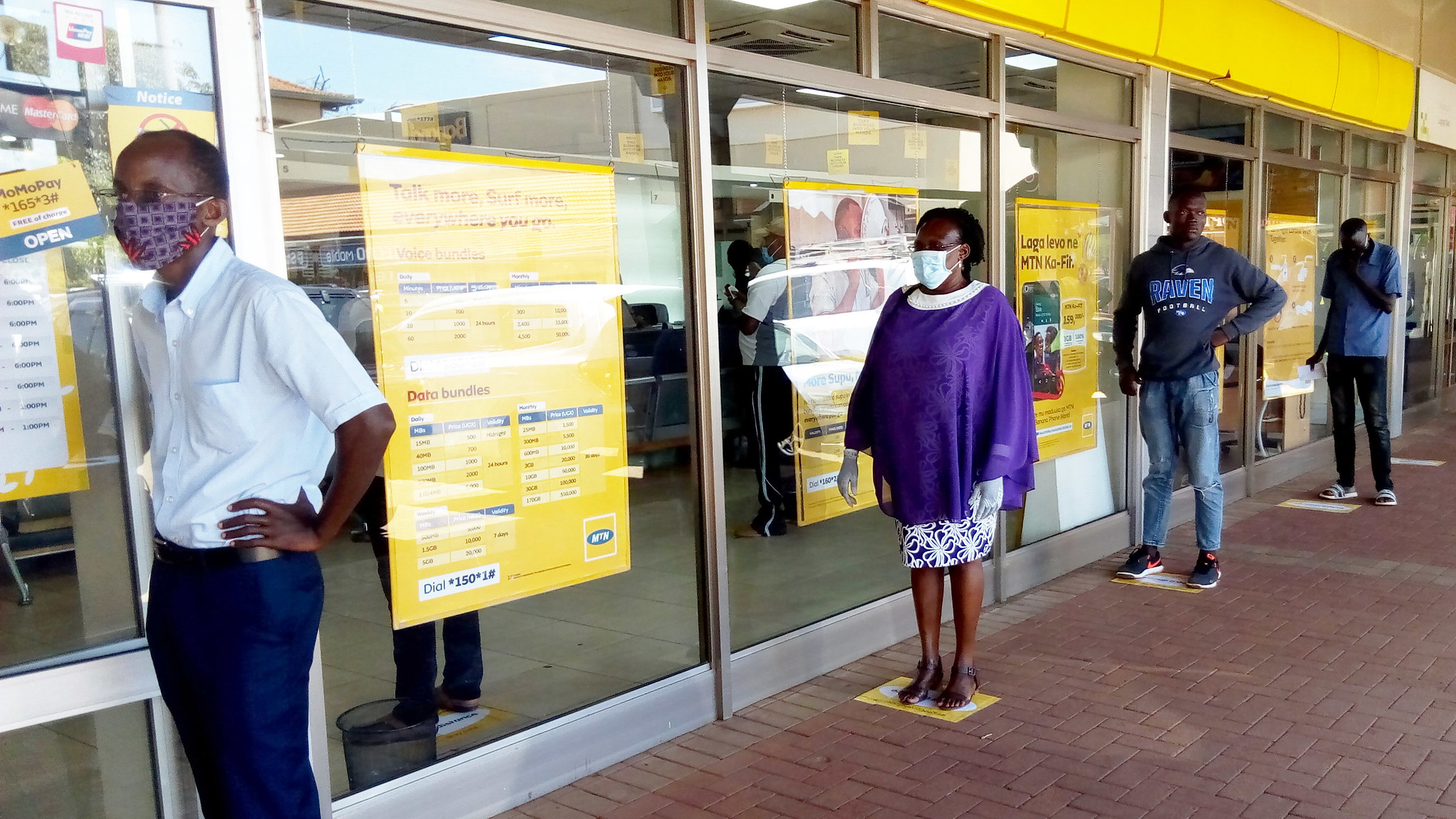 Customers practising social-distancing outside a shop in Kampala, Uganda. The coronavirus pandemic threatens to reverse development progress around the world.