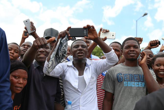 Audience members in Dar es Salaam cheer during a speech by President John Magufuli of Tanzania
