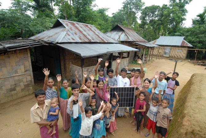 Bangladeshi village celebrating as they display their first solar panel.