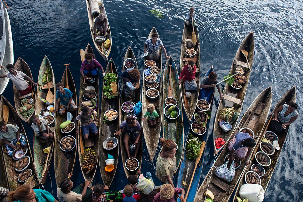Solomon island's locals selling food in artisanal canoas