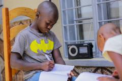 A boy studies at home due to COVID-19, listening to his lessons on the radio every day in Rwanda