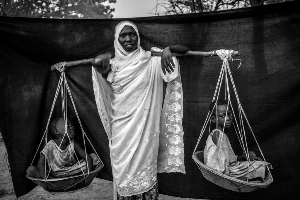 Camp de réfugiés de Doro, comté de Maban, Soudan du Sud – 5 août 2012. Dowla Barik maintient sur son épaule la poutrelle de bois avec laquelle elle a transporté ses six enfants durant les 10 jours qu'a duré sa marche depuis son village de Gabanit dans l'État du Nil Bleu (Soudan) après que de nombreux raids les ont obligé à quitter leur foyer. Photo: Brian Sokol