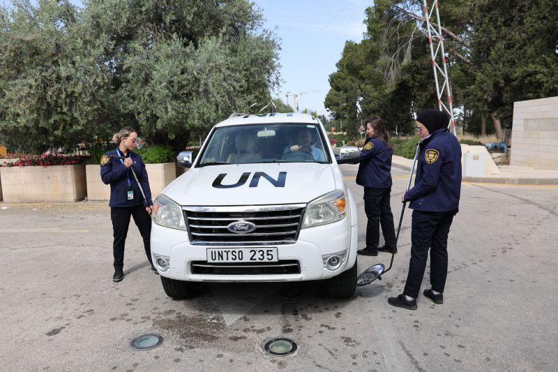 Three female security officers conducting a vehicle search