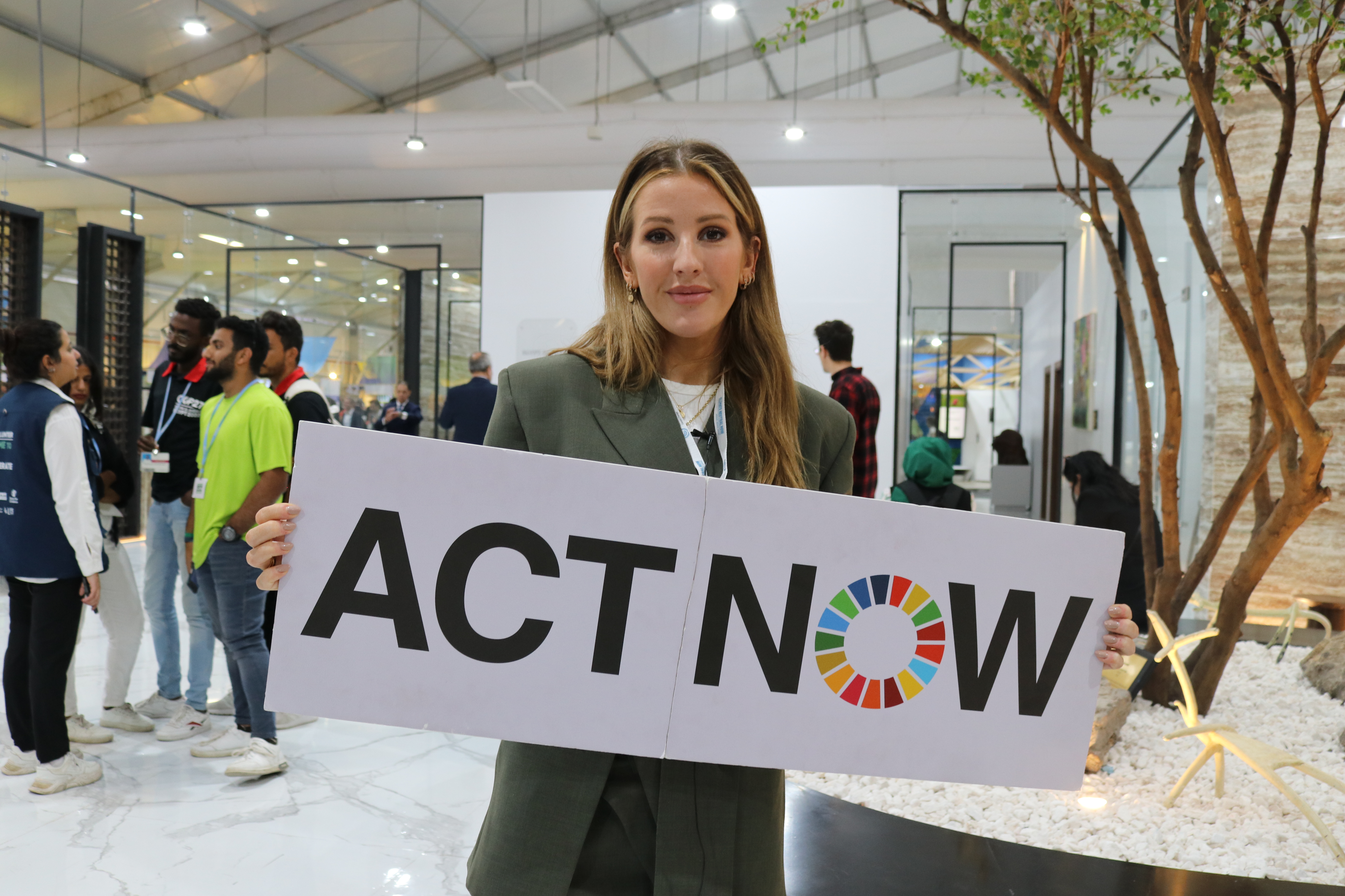 À l'occasion de la Journée de la biodiversité, l'ambassadrice de bonne volonté du PNUE, Ellie Goulding, a appelé à davantage d'actions pour protéger les récifs coralliens. Ellie Goulding tenant la bannière ACTNOW
