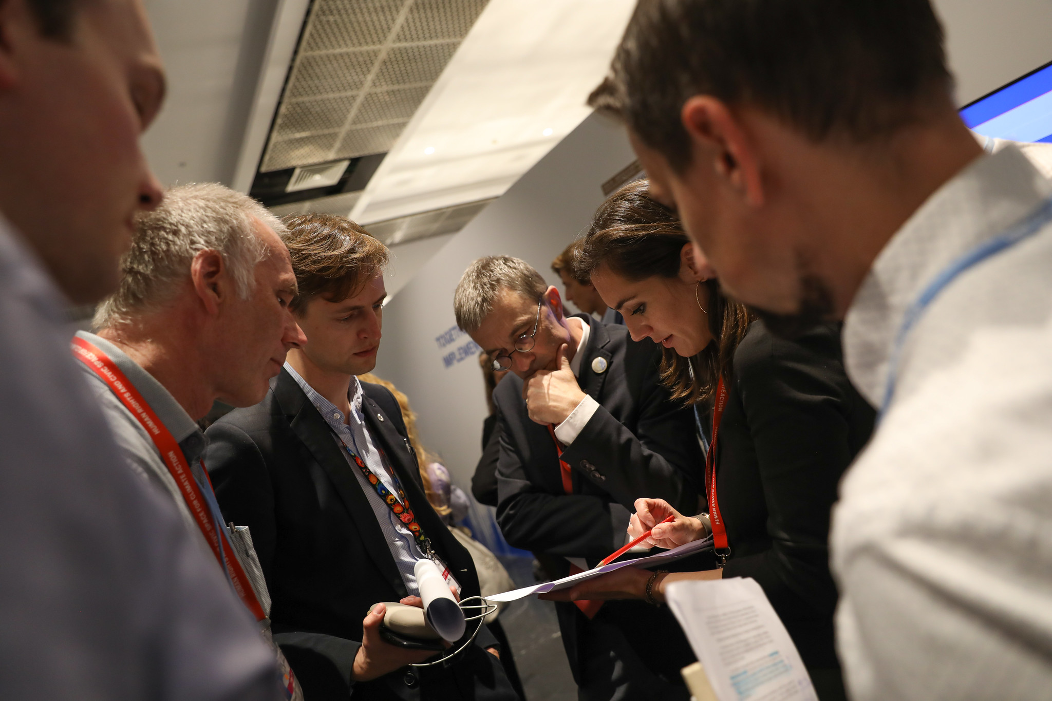 People in a group looking at papers and in a conversation during COP27