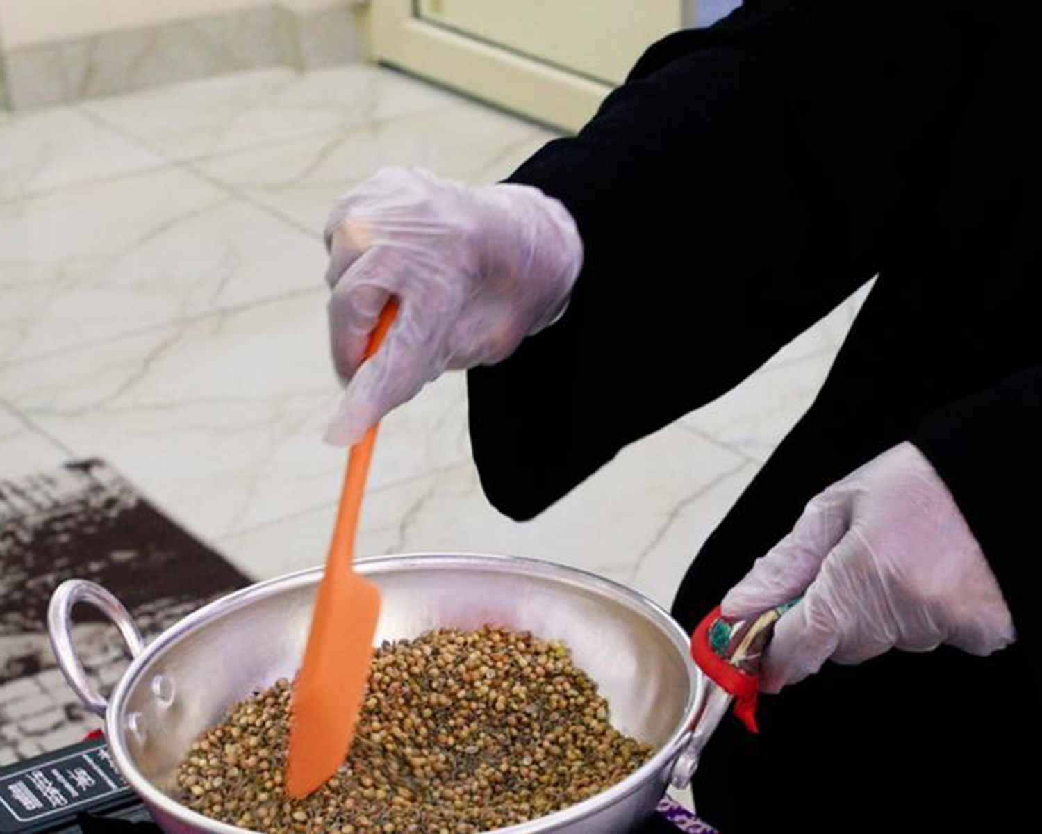 Noora Khalid Musaifer roasts spices before mixing and packaging them in special bottles ready for sale.UN News/Hisae Kawamori