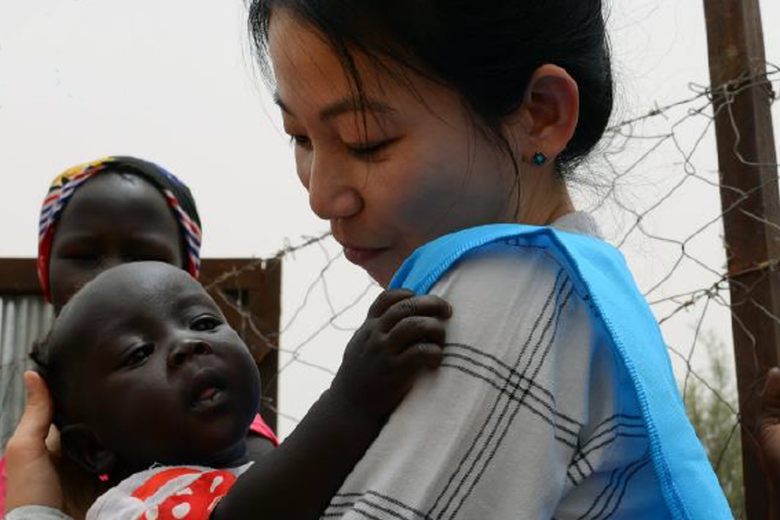 Female aid worker holding baby