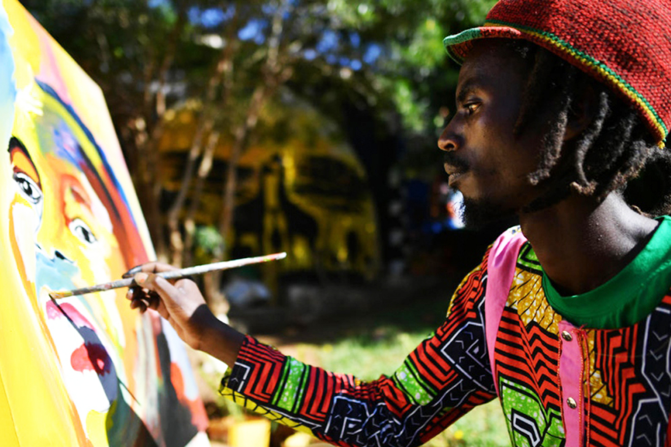 Mike, who fled Burundi in 2015, works on a painting at the art centre.