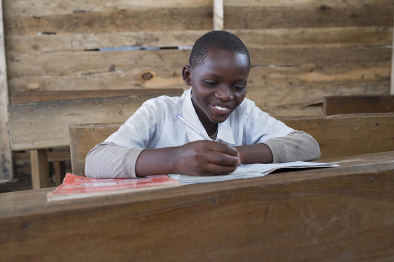 Tulisa sits at his desk in a classroom at Tarse Primary School in Butembo, eastern Democratic Republic of the Congo.
