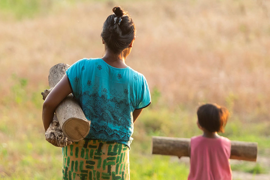 mother and daughter in Myanmar carrying firewood