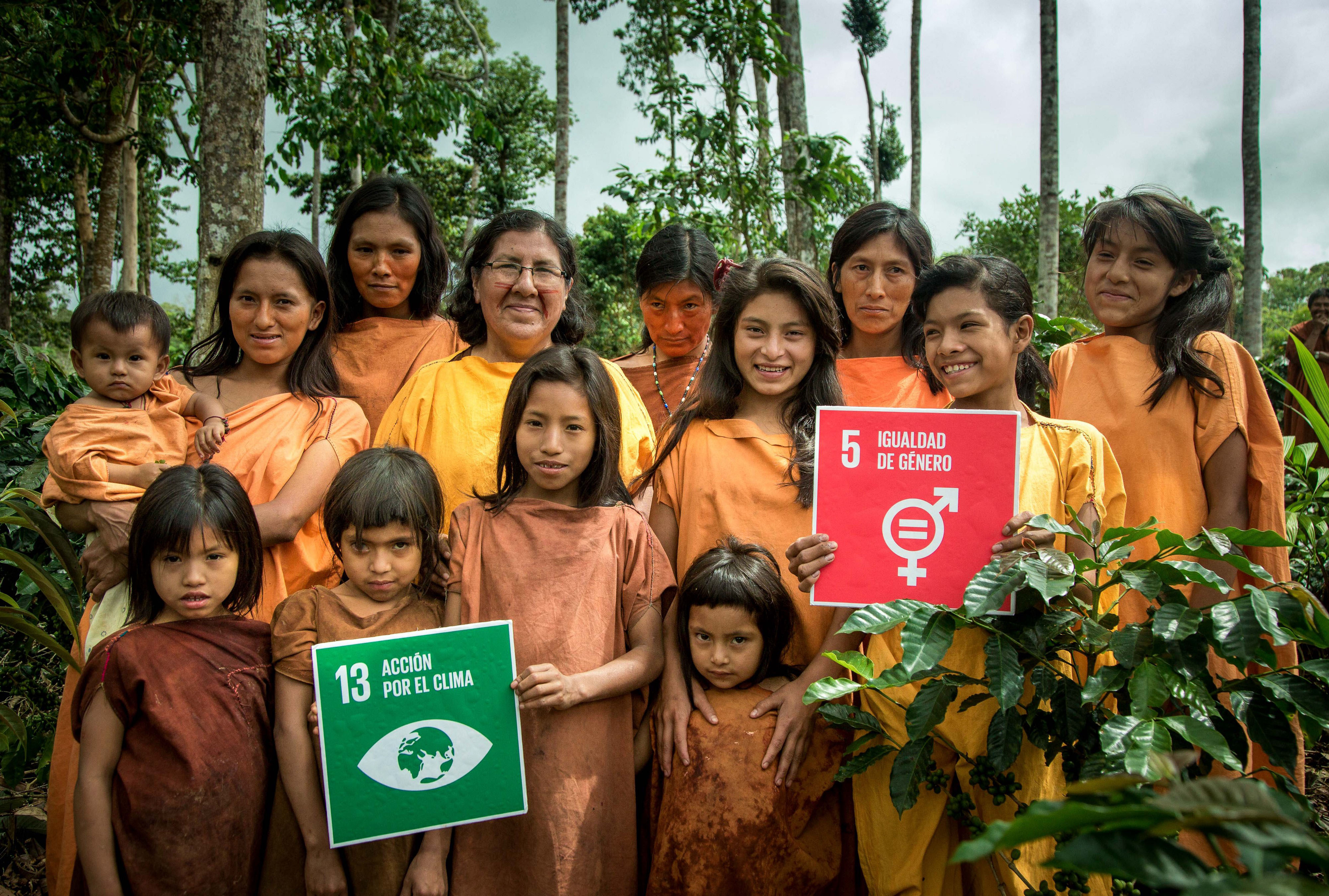 women and children holding up SDG cards