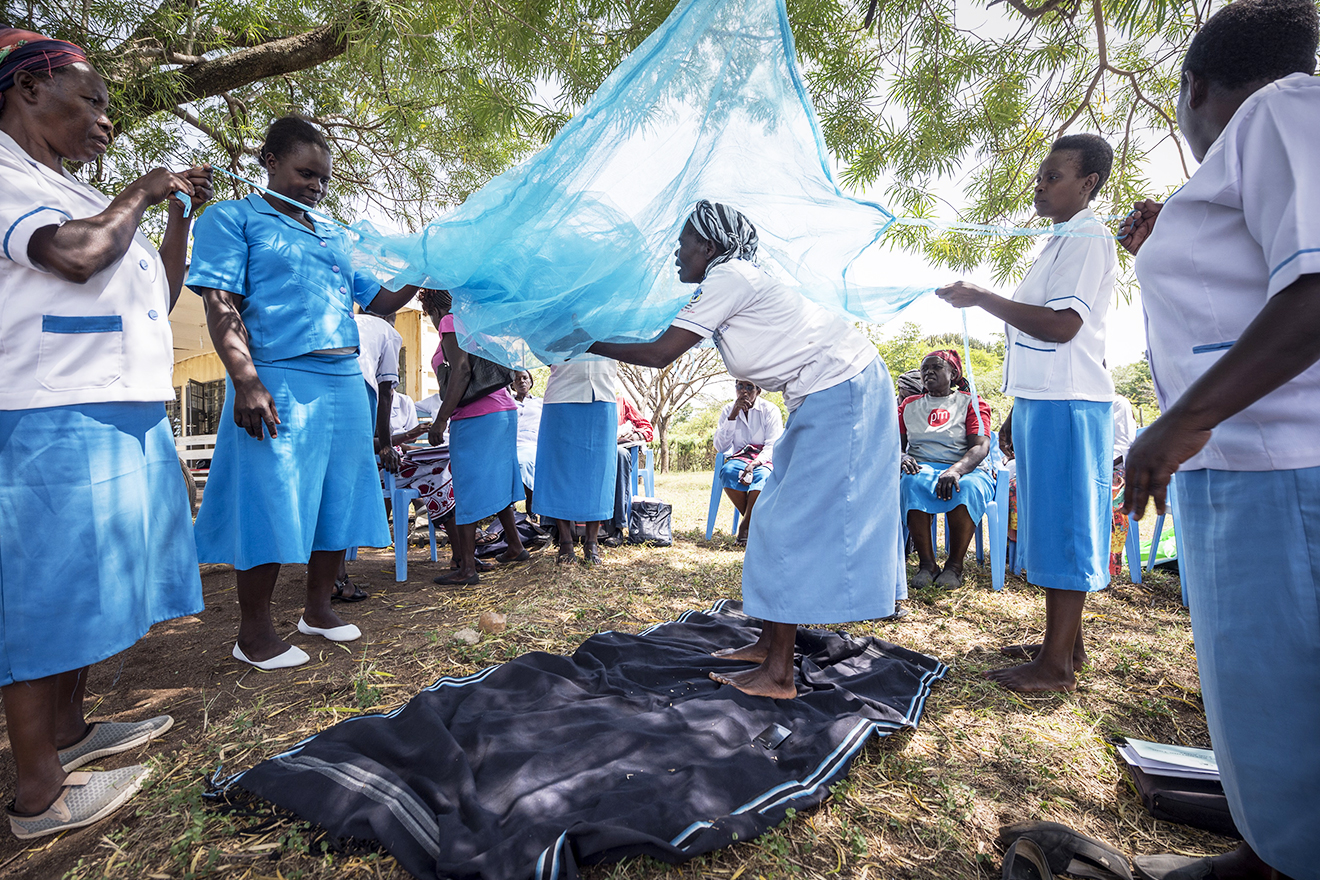 Community health workers demonstrate the use of an insecticide-treated net near Kisumu, Kenya.