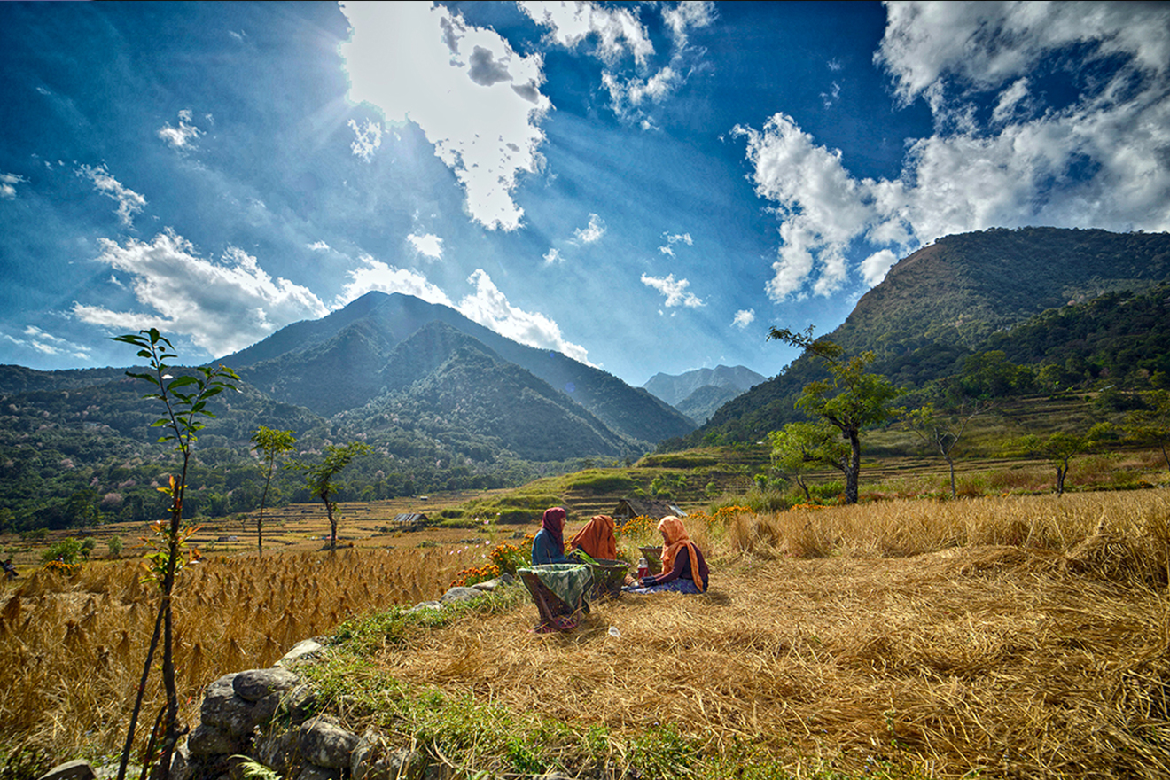 Young girls chatting under the watchful eye of a majestic mountain.